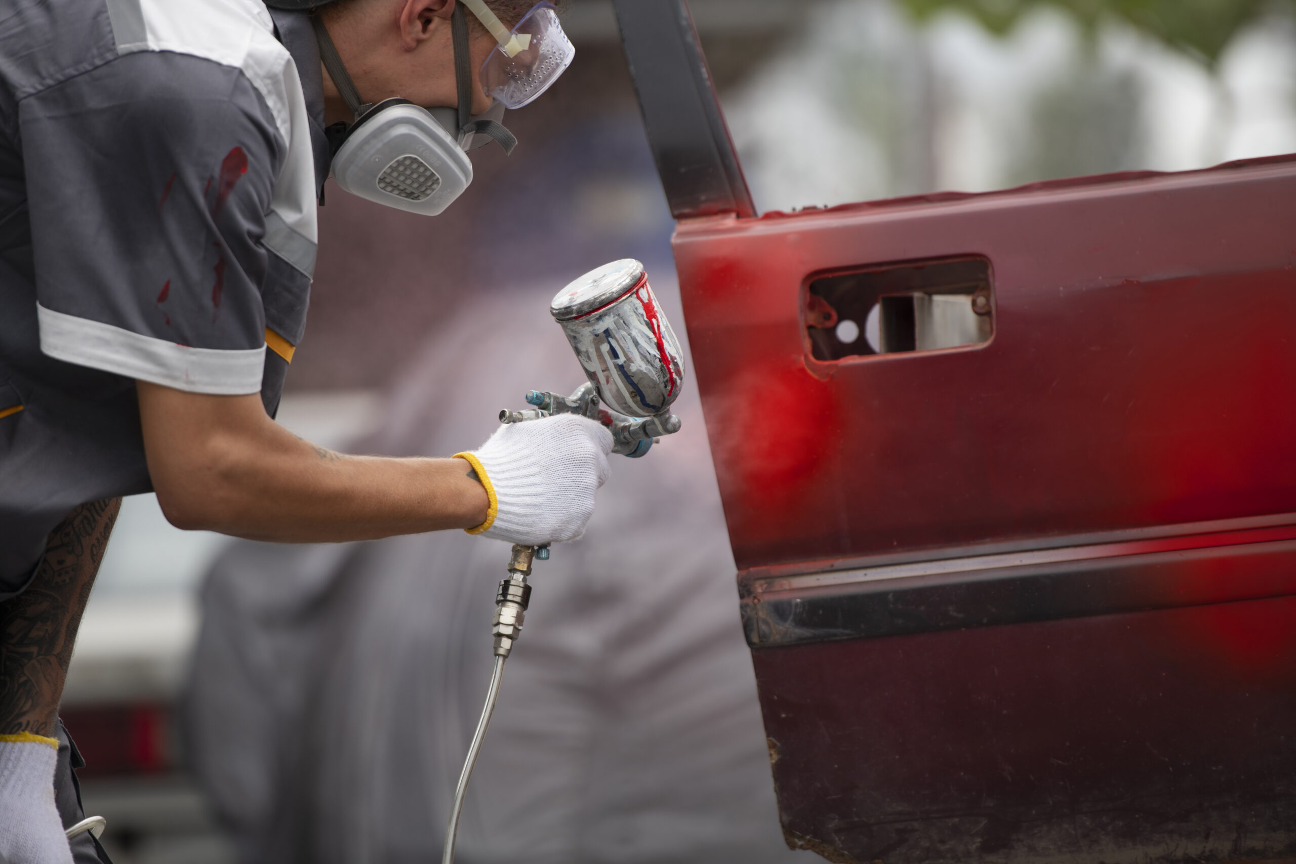 Homem pintando carro, com tintas automotivas Skylack.